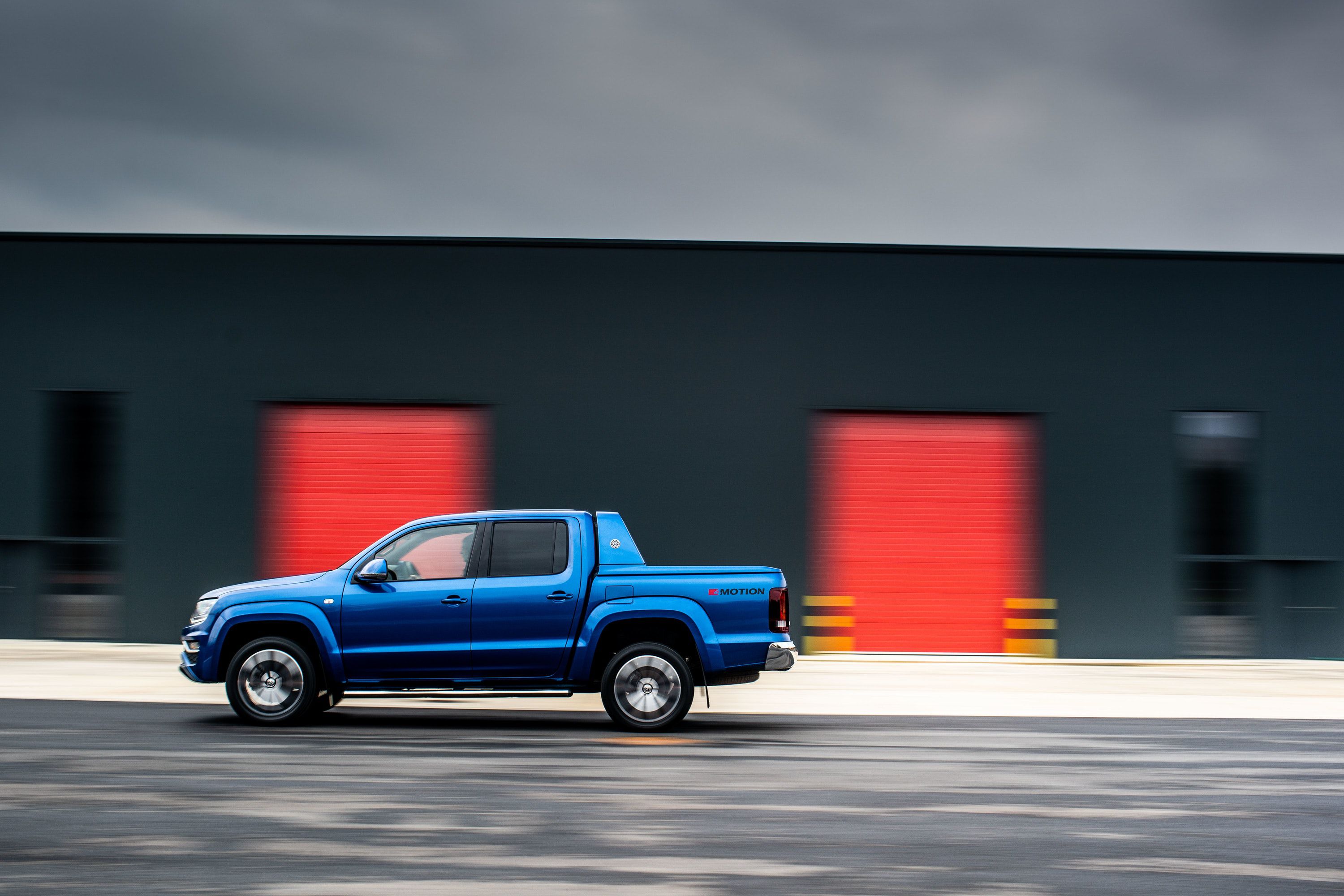 Side view of blue Amarok driving on a road