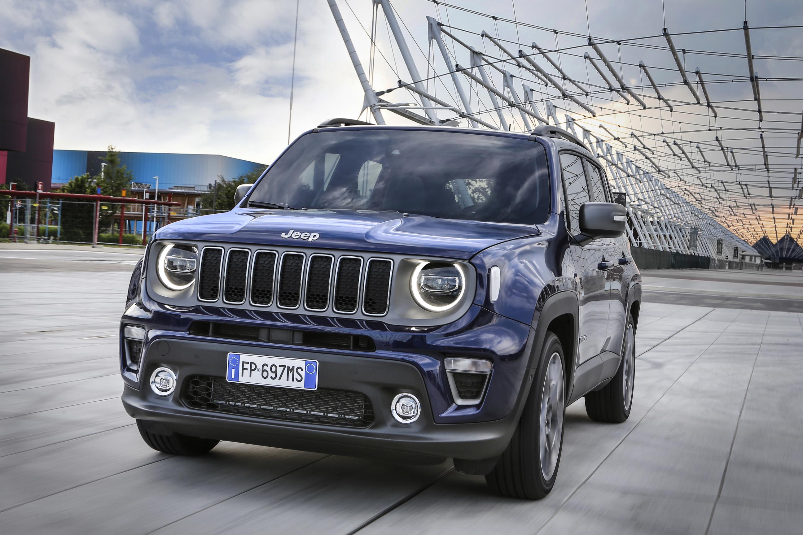 Blue Jeep Renegade parked with sculptural building behind it