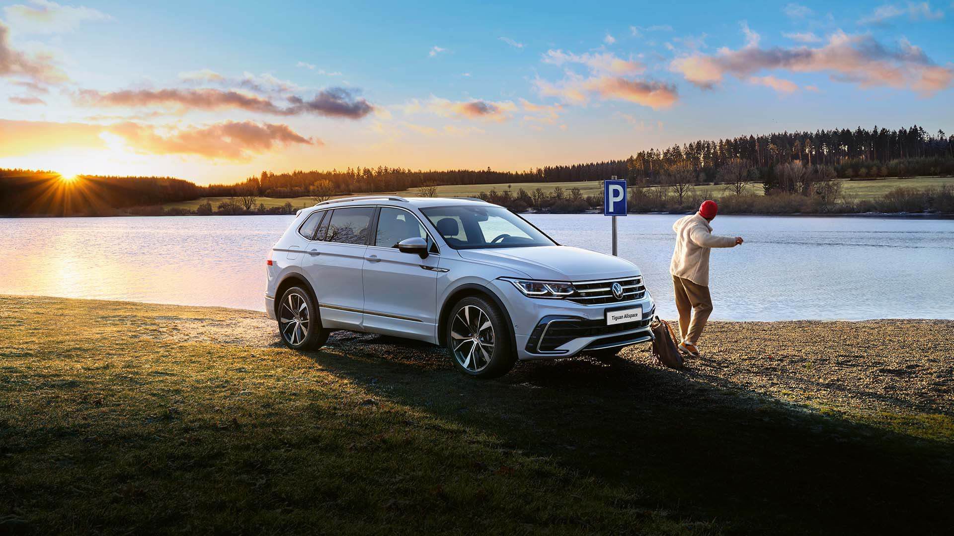 White Volkswagen Tiguan Allspace front parked by a lake
