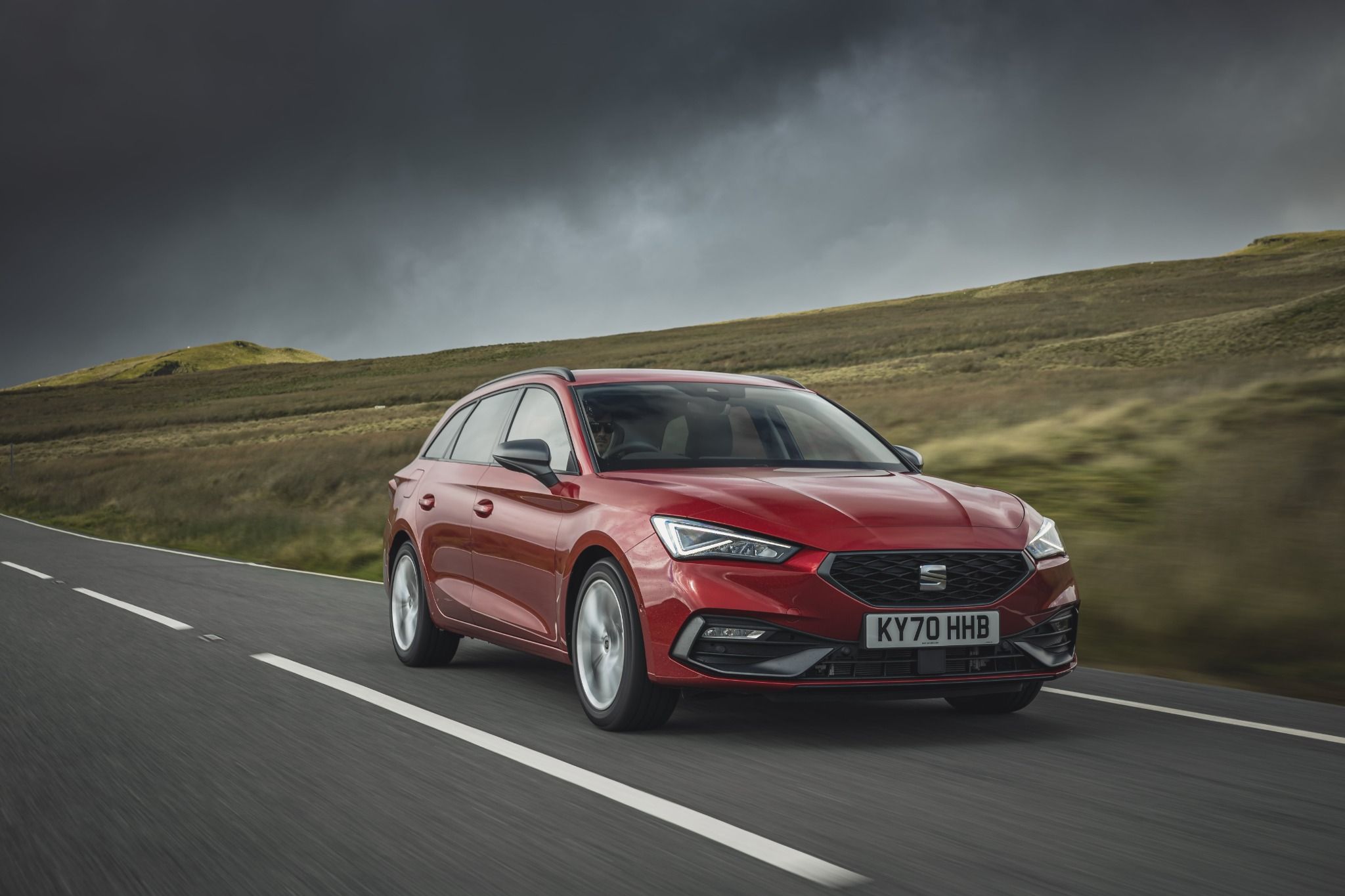 Red SEAT leon estate exterior driving on a road