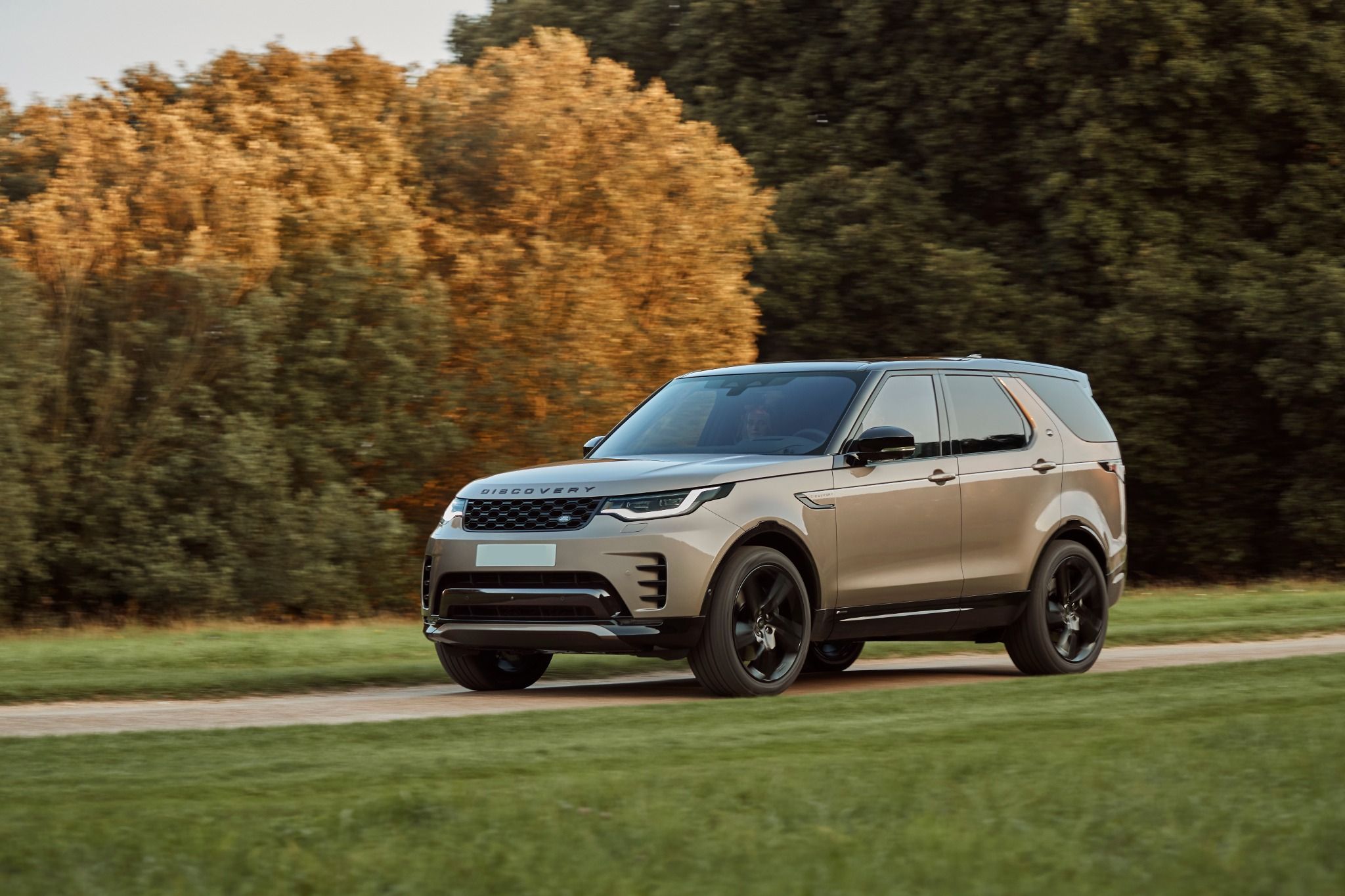 2023 Land Rover discovery driving by trees