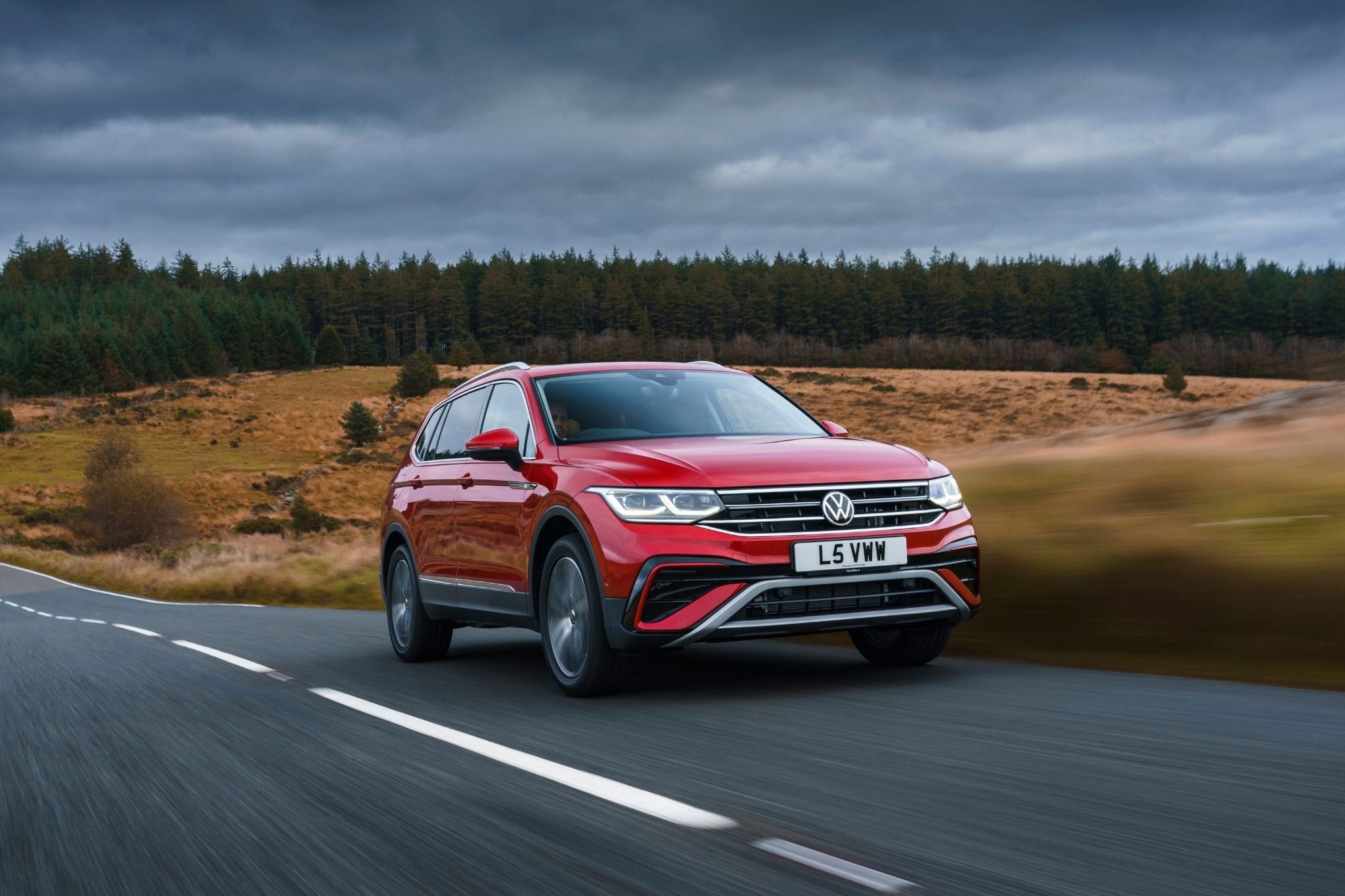 Front view of red Volkswagen Tiguan Allspace driving on a road